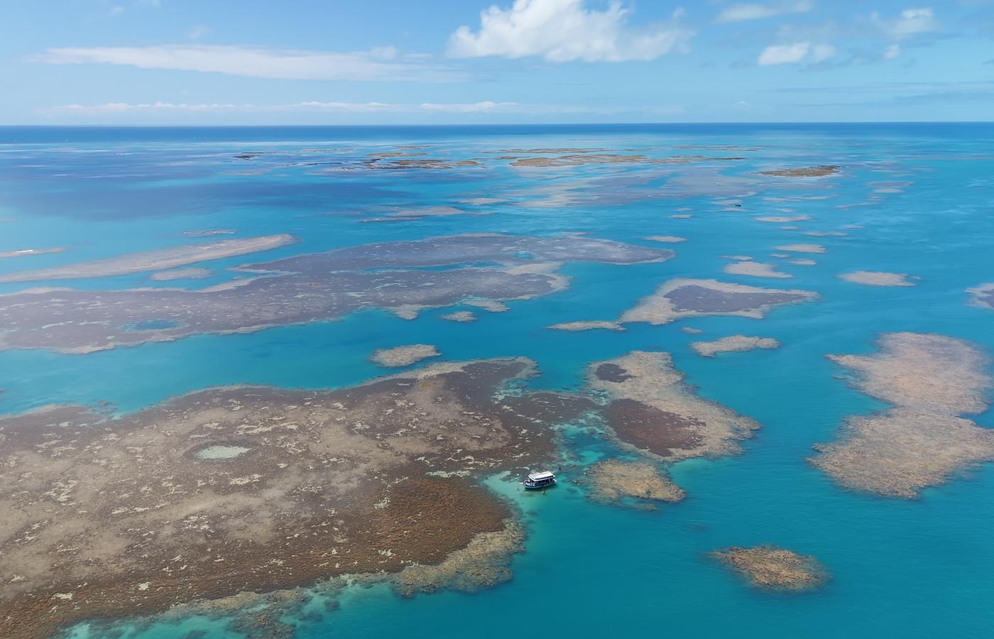 O campo de recifes de Corumbau visto do alto, com um barco fundeado