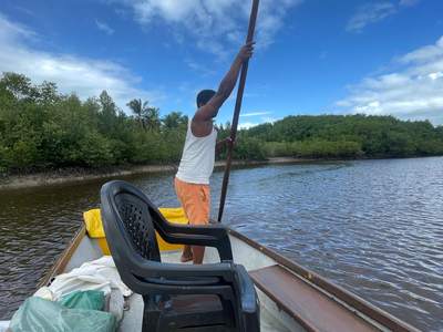 O pescador conduzindo o barco na vara, subindo o rio