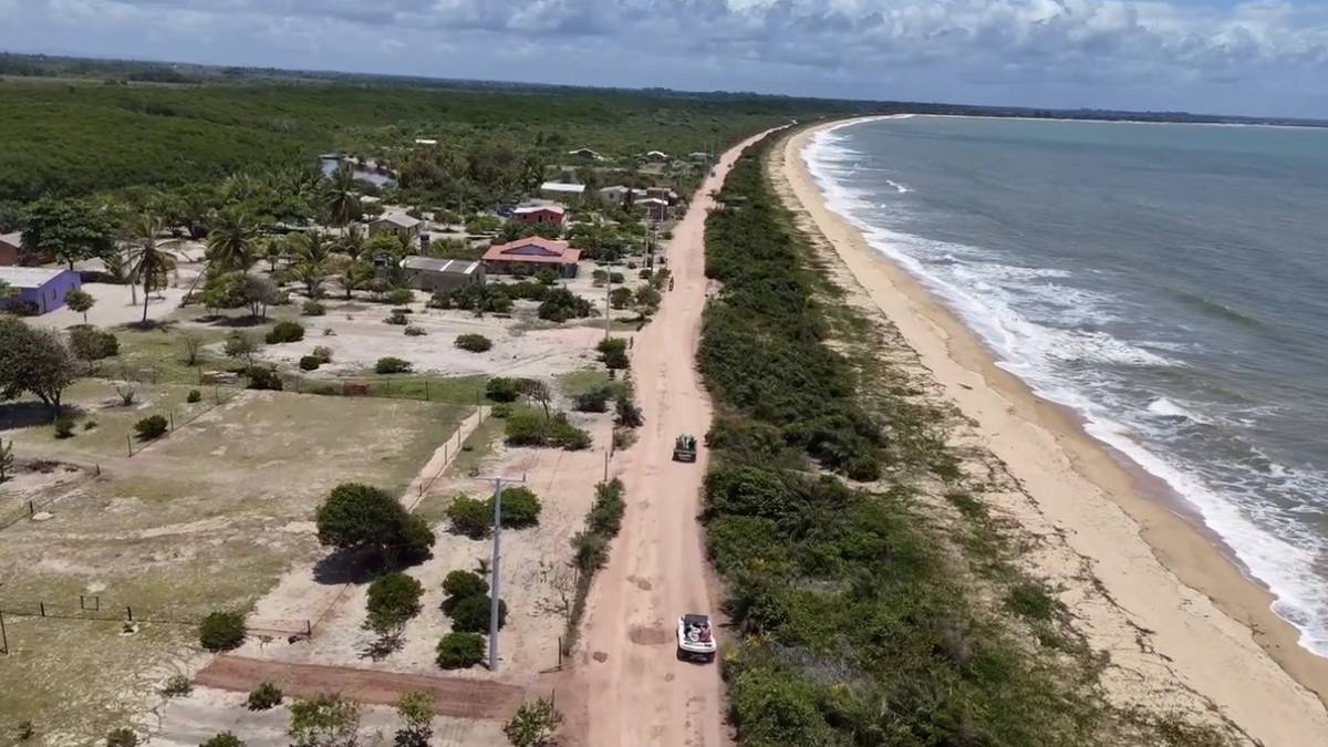 A estrada de areia margeando a praia, vista do alto