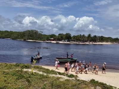 O grupo chegando a pé na beira, com as canoas esperando