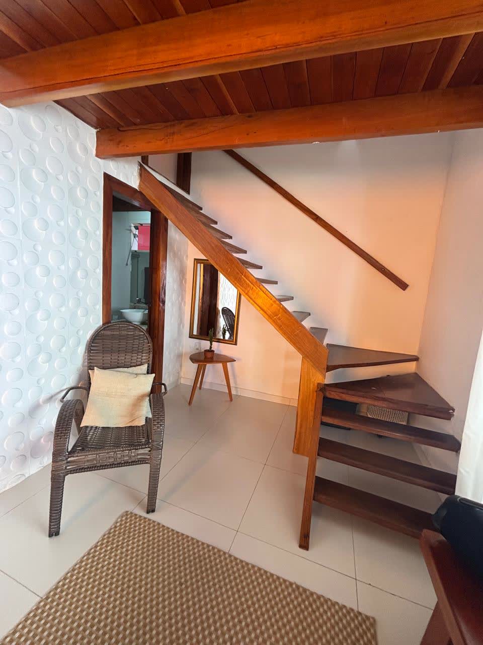 Escada de madeira maciça que sobe para o segundo quarto