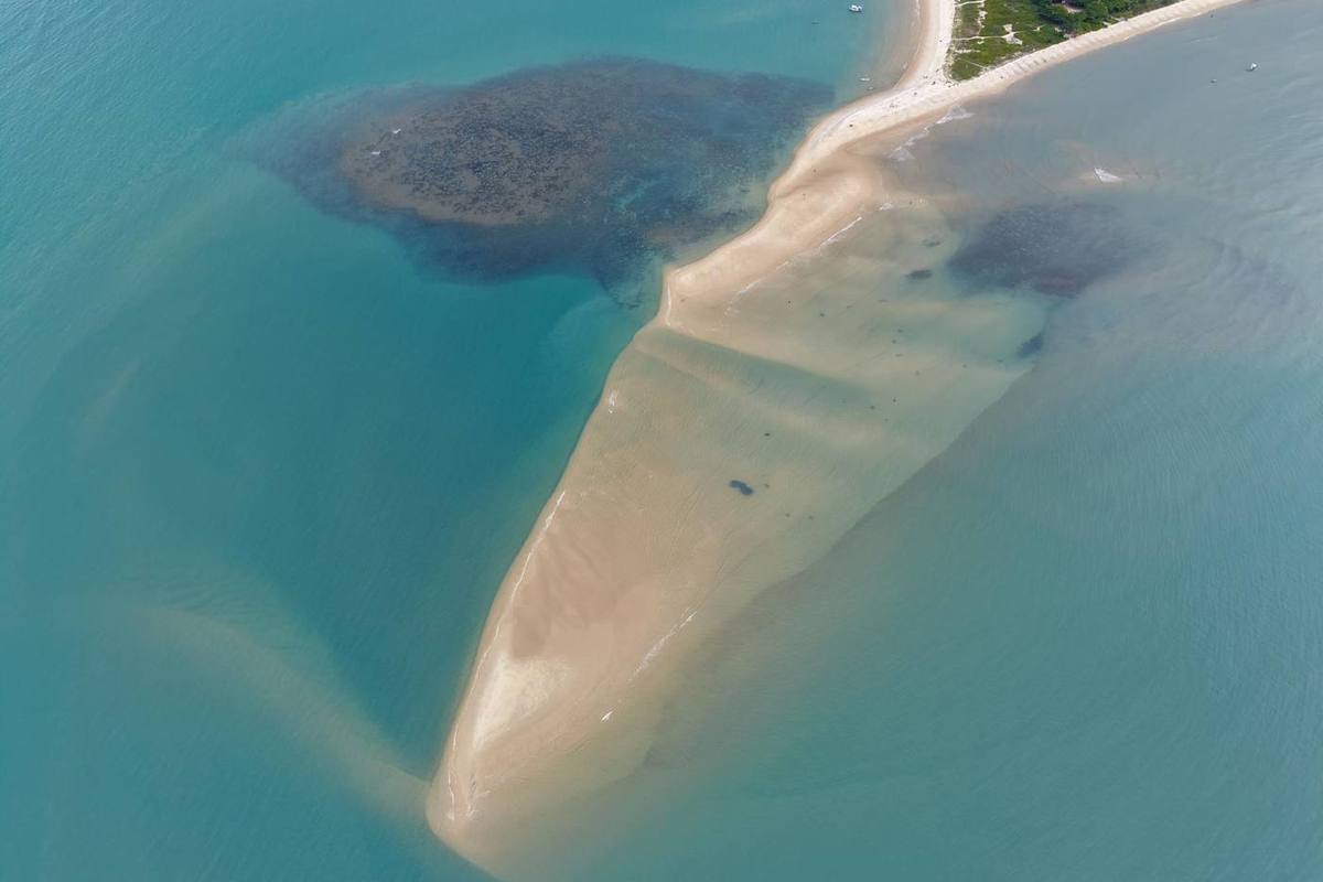 A Ponta do Corumbau vista do alto na maré baixa, com o recife escuro e o banco de areia