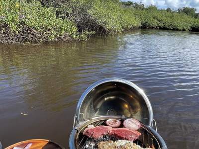 A churrasqueira de bordo, com peixe e carne na grelha