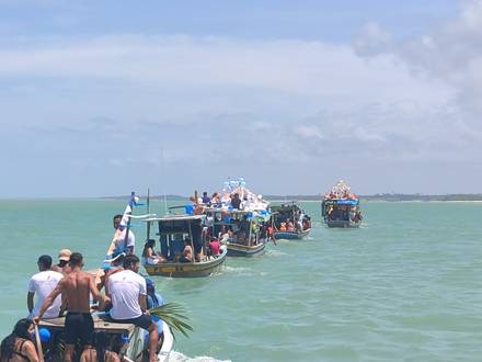 A fila de barcos seguindo pelo mar, vista de dentro da procissão